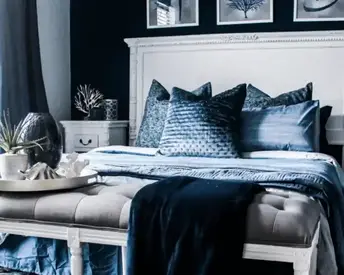 Luxurious bedroom painting idea in deep navy with layered bedding