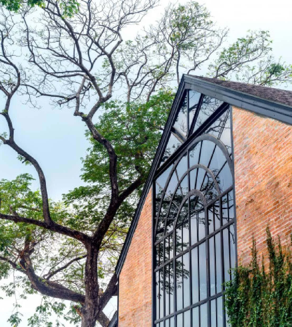 beautiful vintage glass house building with brick wall exterior blue sky_36367 158@2x