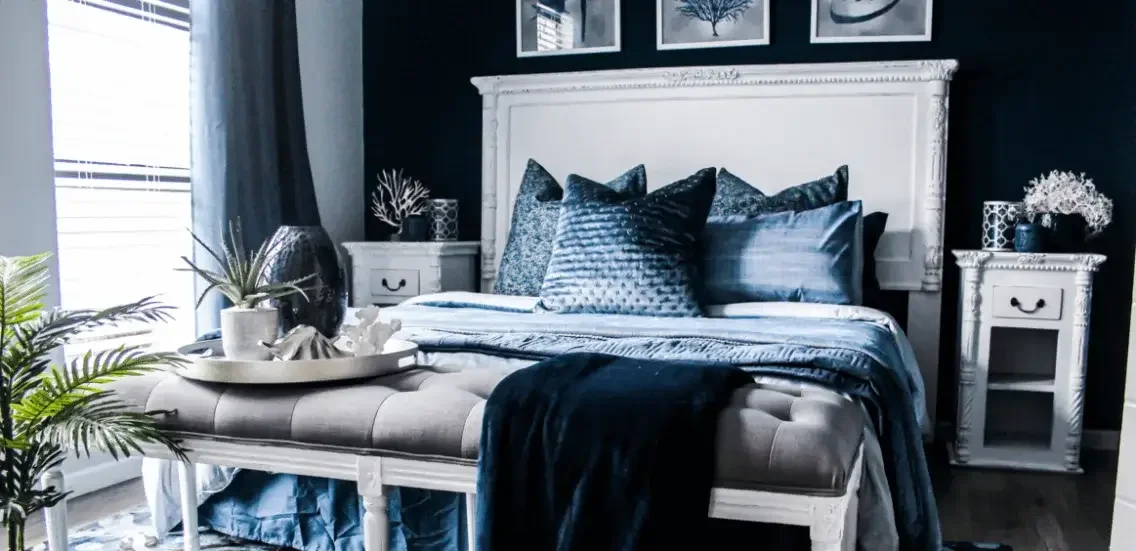 Luxurious bedroom painting idea in deep navy with layered bedding